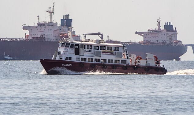 A boat sails in front of a crude oil tanker anchored on Lake Maracaibo near Maracaibo, Zulia state, Venezuela, on December 18, 2025