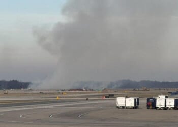 Smoke billows near a Dulles International Airport runway in Virginia on Dec. 13, 2025.