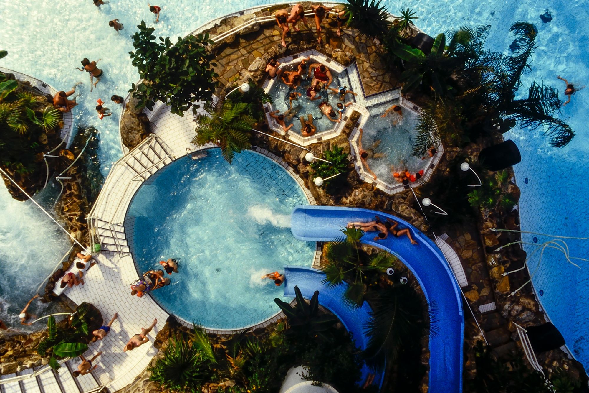 An image collage containing 1 images, Image 1 shows An aerial view of a Costa del Sol hotel swimming pool complex with people in the pools and hot tubs