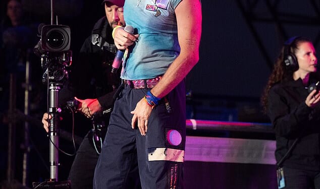 Chris Martin wearing one of his signature tie-dyed t-shirts for his performance at Glastonbury in summer 2024