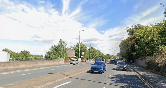 LOMGMOOR LANE with cars driving and trees lining the street.