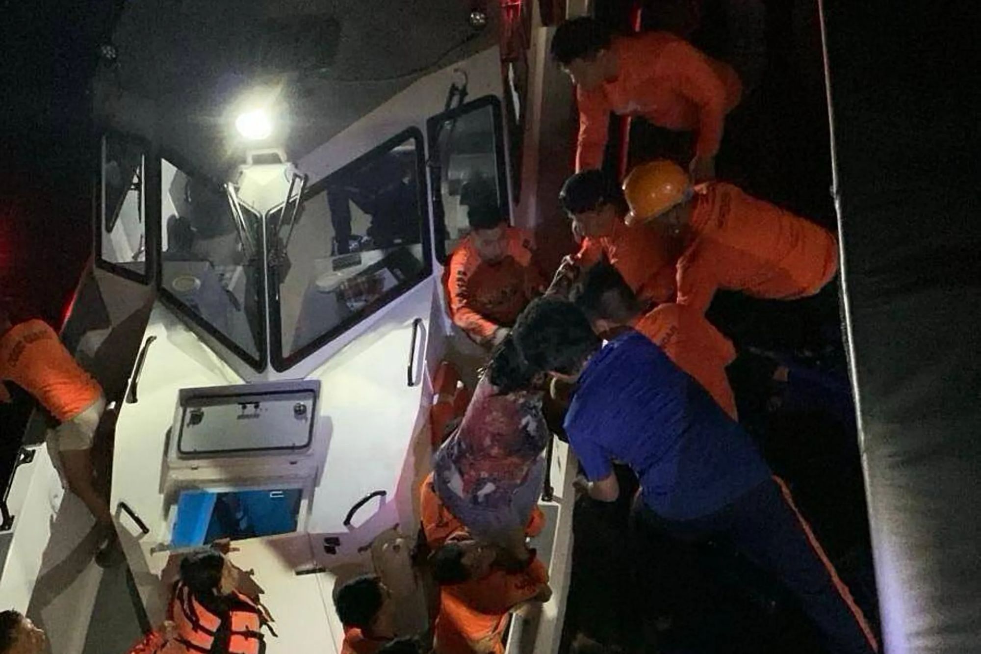 An image collage containing 1 images, Image 1 shows Philippine Coast Guard personnel assist people from the M/V Trisha Kerstin 3 at night