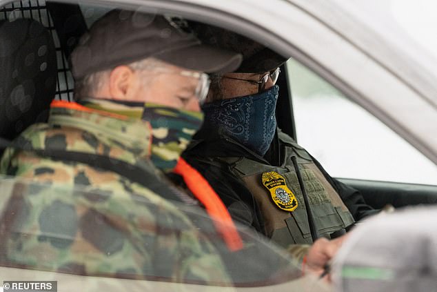 Immigration and Customs Enforcement (ICE) agents sit in a parked vehicle amid a reported federal immigration operation targeting the Somali community, in Minneapolis, Minnesota, US, December 10, 2025