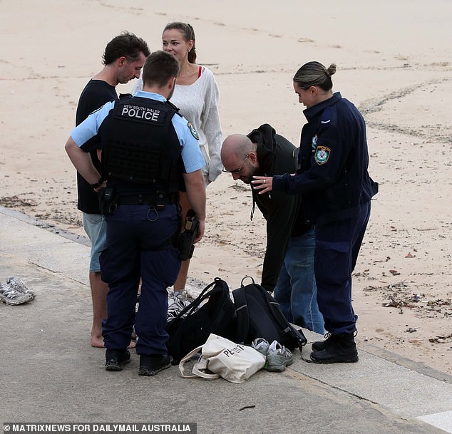 Police officers are seen speaking to beach-goers at Coogee on Thursday after the swimmer went missing