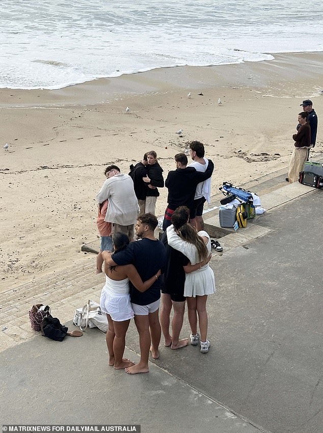 Revellers are seen at Coogee Beach, where a search is underway for a missing swimmer