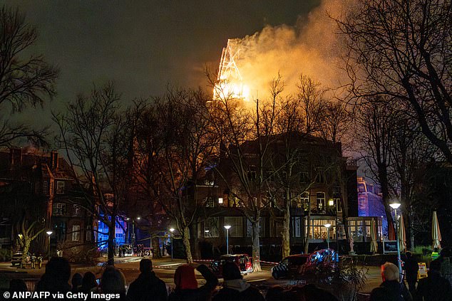 People look at the tower of the Vondelkerk church on fire during New Year's Eve, in Amsterdam on January 1, 2026