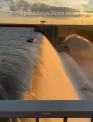 Moment four men cling to boat on edge of DAM