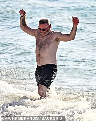 The sports pundit jumped as he got splashed by a wave