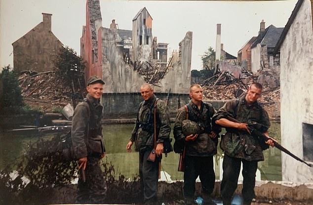 Extras by the set of a wrecked Ramelle - the fictional French town where the climactic battle unfolds