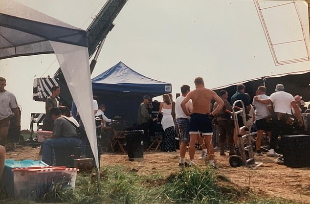 Director Steven Spielberg, centre, in a cap, talking to the wife of actor Tom Sizemore, who played Sergeant Mike Horvath