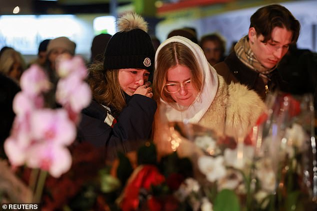 People react outside the 'Le Constellation' bar, after a fire and explosion during a New Year's Eve party where several people died and others were injured, according to Swiss police, in the upscale ski resort of Crans-Montana in southwestern Switzerland, January 1, 2026
