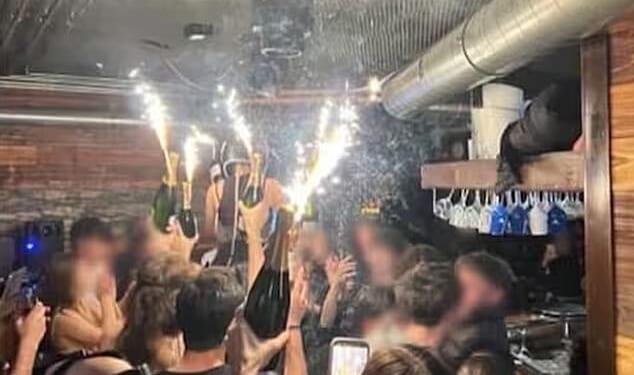 A photo appears to show the moment champagne sparklers set fire to material on the ceiling of the Swiss nightclub