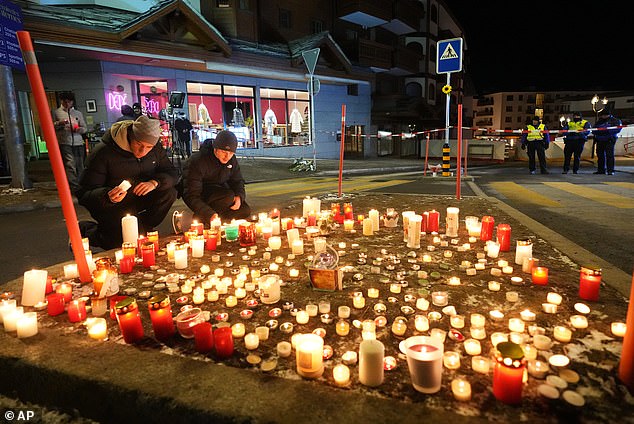 People lay candles near the Le Constellation bar, where a devastating fire left dead and injured during the New Year's celebrations in Crans-Montana, Swiss Alps, Switzerland, Thursday, January 1, 2026
