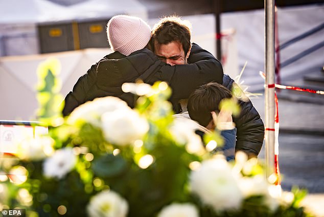 People console one another near the Le Constellation bar
