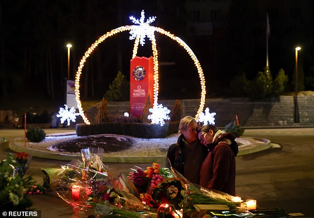 A pair of people embrace near the site of the bar on January 1, 2026