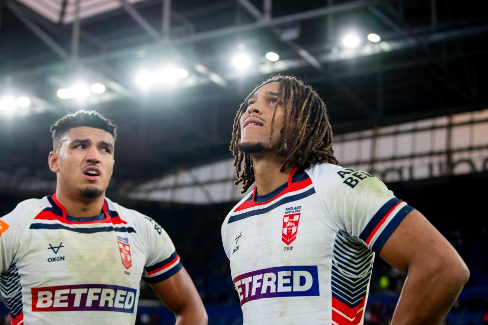 Two rugby players from England look up with expressions of disappointment.