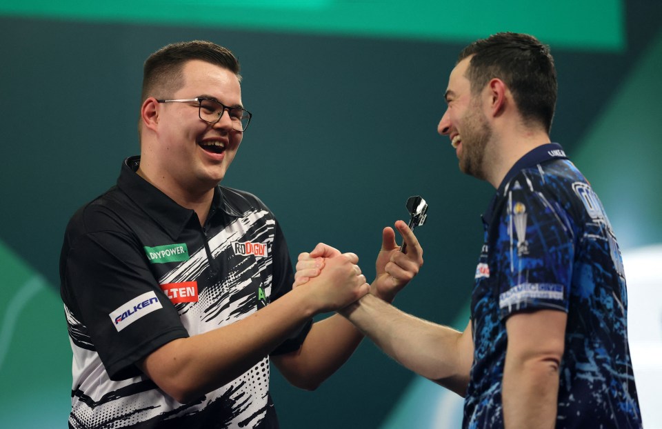 Gian van Veen shaking hands with Luke Humphries after winning their quarter-final match at the World Darts Championship.