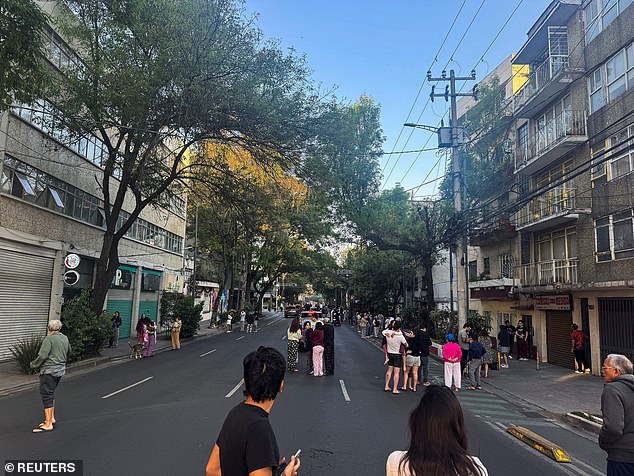 People wait on the street after evacuating following an earthquake, in Mexico City, Mexico, January 2, 2026