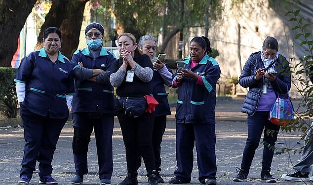 People stand after leaving a building following an earthquake, Mexico City, Mexico, January 2, 2026