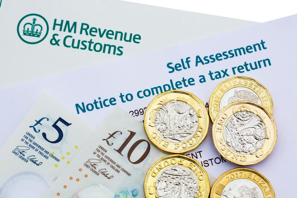 HMRC Self Assessment tax return notice with British pound notes and coins.