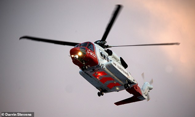 The HM Coastguard helicopter hovers above the sea as part of the rescue operation