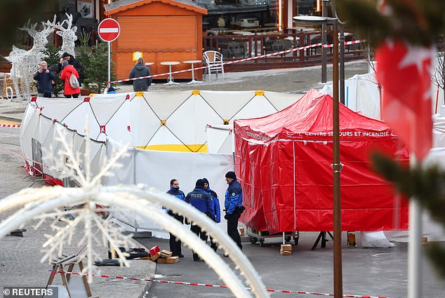 Police stand by tents outstide Le Constellation bar the day after the fire ripped through it, killing 47