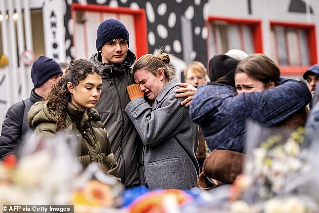 Mourners gather near Le Constellation