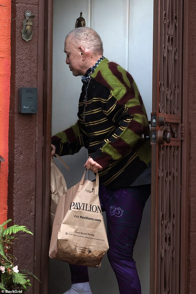 Wearing a striped sweater, rosary, and with no shoes on, a frail Rourke looked somber during his rare public outing, amid continued turmoil in his personal life