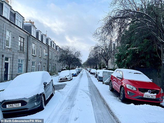 Snow covers roads and cars on a residential street in Aberdeen, Scotland