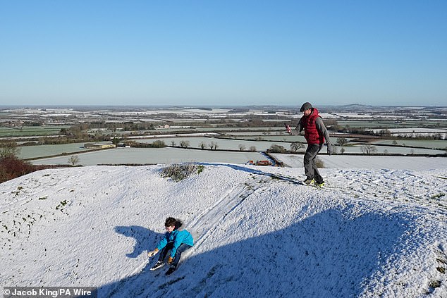 A child sledges down snowy hills at Burton Dassett Hills Country Park in Warwickshire
