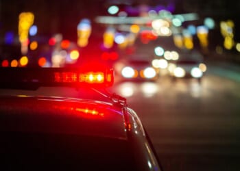 Police car lights at night in a city.