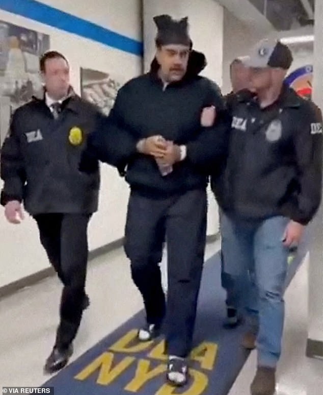 In earlier footage at the US Drug Enforcement Administration, Maduro wished officers a 'Happy New Year' as he shuffled down the hallway