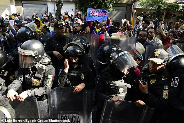 Riot police prevent protesters from reaching the US embassy during a demonstration