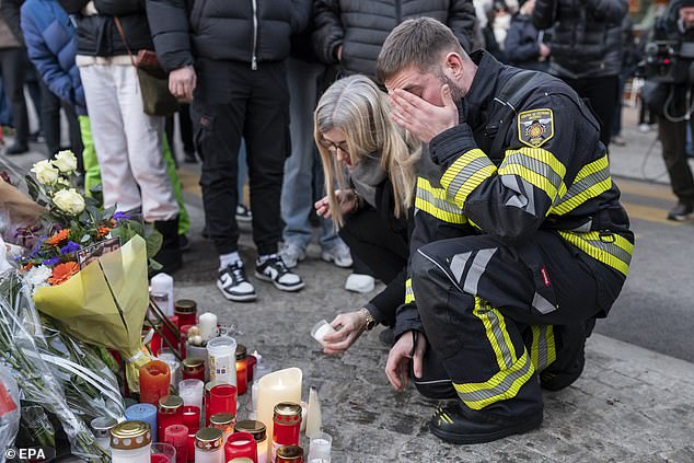 firefighter of the regional fire and rescue service Sapeur-Pompiers de Sierre reacts as he lays down a candle at a memorial site for the fatal fire