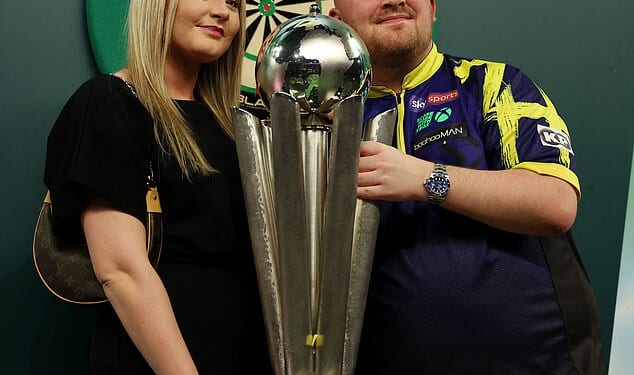 Luke Littler (pictured with his girlfriend Faith Millar) could be set to lose nearly half of his huge £1million prize cheque, after he became the first ever man in 10 years to win back-to-back World Championships at Alexandra Palace