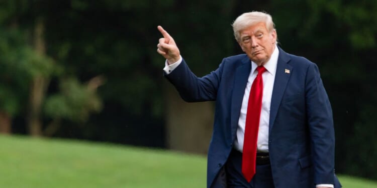 U.S. President Donald Trump walks on the south lawn of the White House and points up at the new flag on July 13, 2025 in Washington, DC.