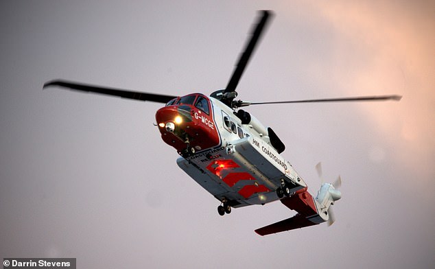 The HM Coastguard helicopter hovers above the sea as part of the rescue operation