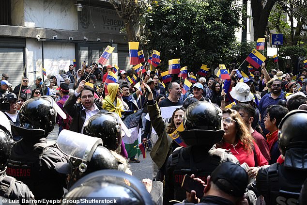 Riot police prevent protesters from reaching the US embassy during a demonstration against the United States government for the detention of Venezuelan President Nicolás Maduro
