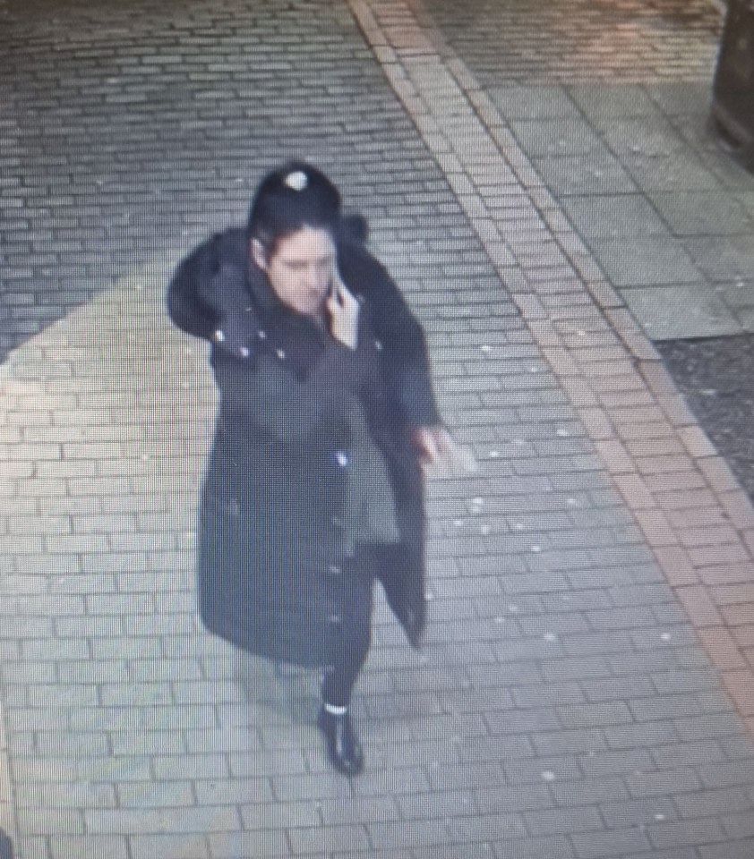 CCTV image of a woman, Kayleigh, in a dark coat walking and talking on a phone.