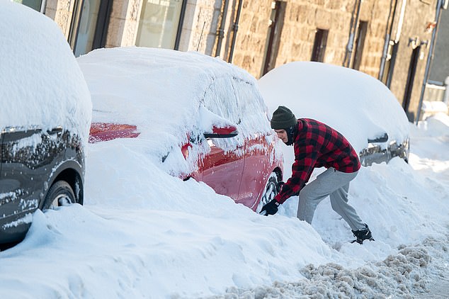 SCOTLAND -- Heavy snow in north-east Scotland as a man attempts to dig a car out on Sunday