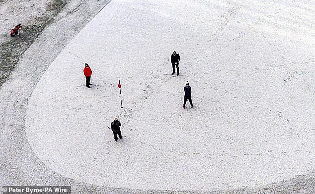 LIVERPOOL -- Golfers putt on the 5th Green on Lee Park Golf course with a layer of snow in Lee Park, January 4, 2026