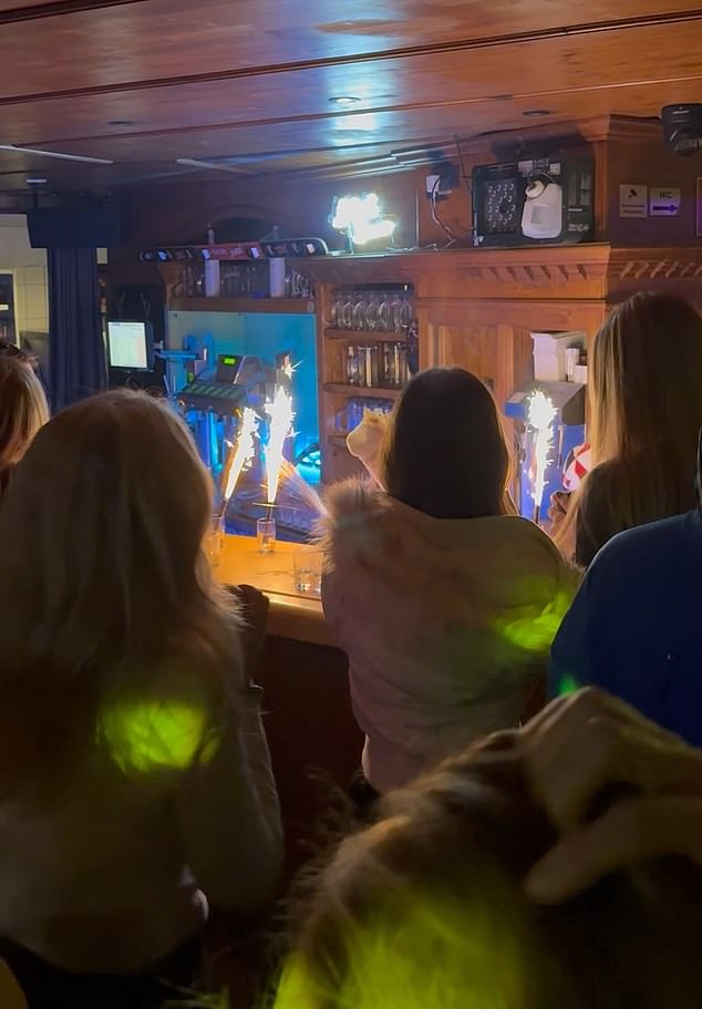Ignited sparklers can be seen in three glasses on the counter, just metres from the Austrian Alps bar's wooden ceiling
