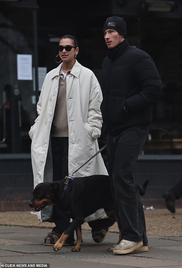 Dua looked as stylish as ever in a cream trench coat and shades while Callum wrapped up warm in a black padded coat and hat