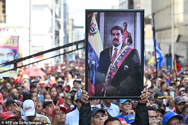 A supporter of ousted Venezuela's President Nicolas Maduro carries his portrait during a rally outside the National Assembly in Caracas