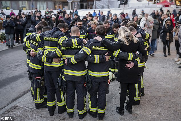 Firefighters of the regional fire and rescue service Sapeur-Pompiers de Sierre gather to pay their respects to the victims of the deadly fire
