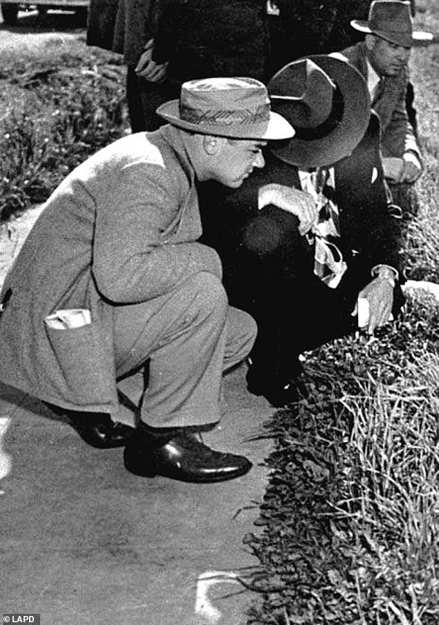 Police look at Short's body, found bisected above the waist and carefully posed in a vacant lot in the Leimert Park area in the early hours of January 15, 1947