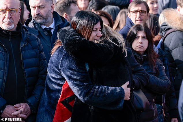 Mourners hug each other during the funeral of 16-year-old Riccardo Minghetti