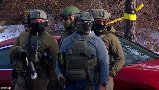 Life-saving aid was rendered, but it is unclear what the woman's condition is. Senator Tina Smith said the woman was a US citizen (pictured: federal agents at the scene)