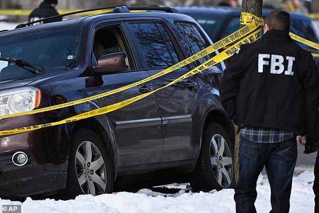 Pictured: An FBI officer looking at the woman's car