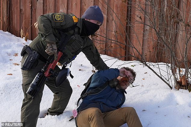 Pictured: A man being retained by a federal agent on Wednesday